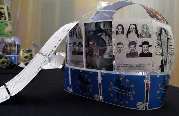 Eine Installation mit Bildern von Menschen verschiedener Kulturen und einem EU-Motiv.