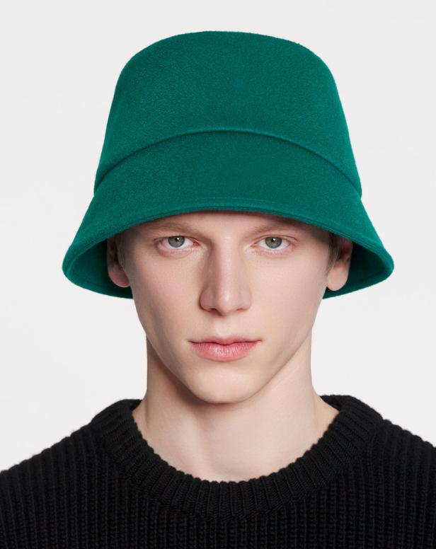 Ein Mann mit einem grünen Fischerhut und einem schwarzen Pullover blickt in die Kamera.