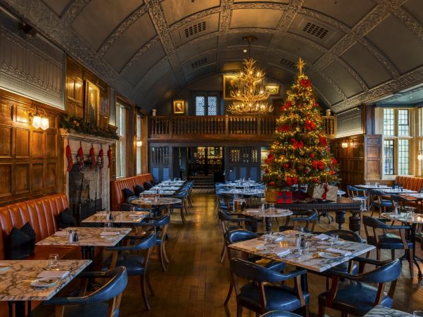Ein festlich geschmücktes Restaurant mit einem großen Weihnachtsbaum.