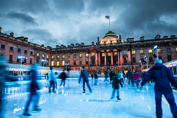 Menschen laufen auf einer Eisbahn vor dem Somerset House in London.
