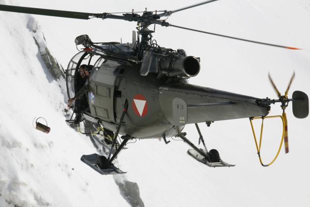 Ein Soldat wirft einen Sprengkörper aus einem "Alouette"-Hubschrauber.