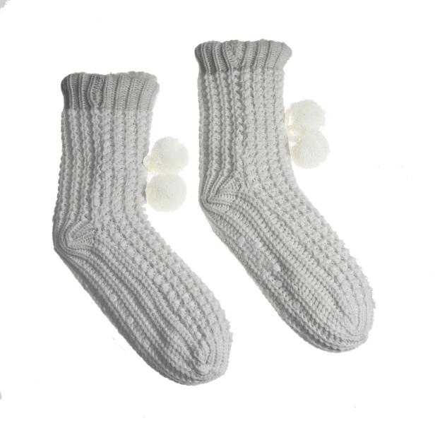 Zwei graue, gestrickte Socken mit weißen Bommeln.