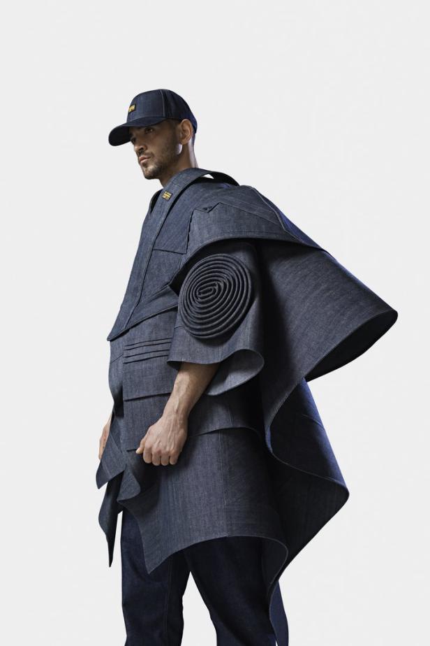 Ein Mann trägt eine ausgefallene Jacke und eine passende Kappe aus dunklem Denim.
