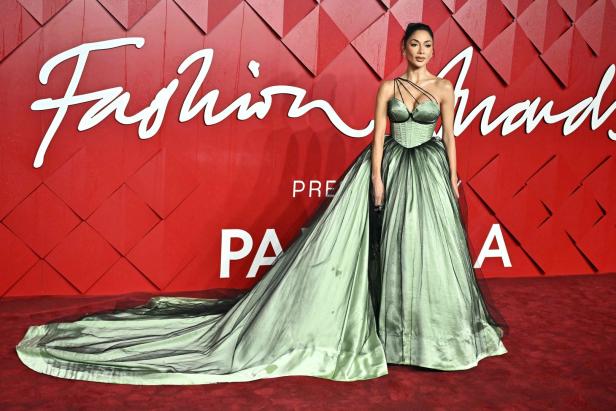 Eine Frau in einem grünen Kleid auf dem roten Teppich der Fashion Awards.