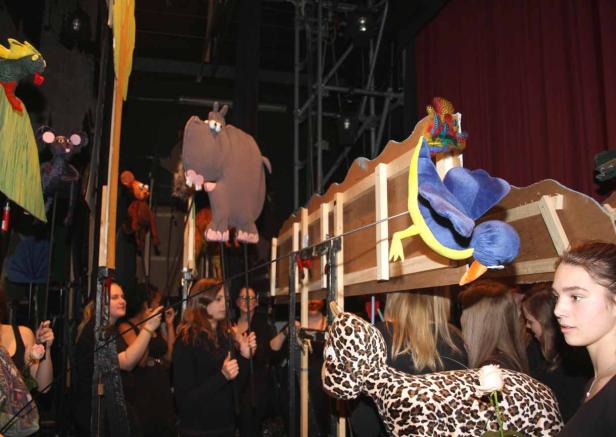 Puppenspielerinnen führen ein Stück mit einem Nilpferd, einem Vogel und anderen Tierpuppen auf.