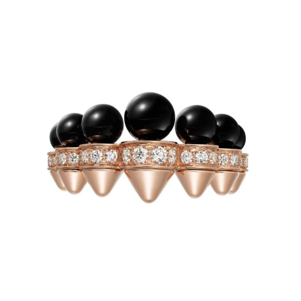 Ein goldener Ring mit schwarzen Kugeln und Diamanten auf einem weißen Hintergrund.