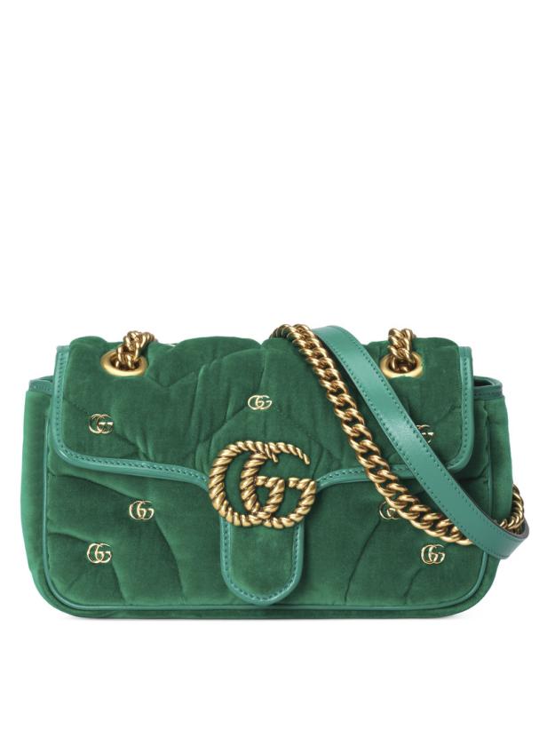Eine grüne Gucci Marmont Handtasche aus Samt mit goldenen Details.
