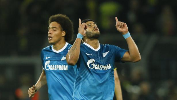 Zwei Fußballspieler in blauen Trikots jubeln auf dem Spielfeld.