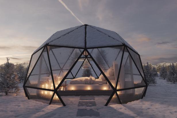 Ein gläsernes Iglu-Hotelzimmer im Schnee bei Dämmerung.