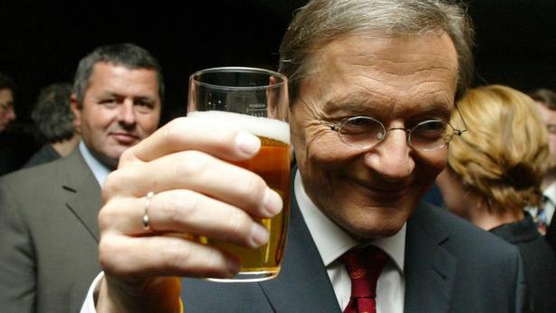 Politiker, die in Bratwürste beißen und Bier trinken
