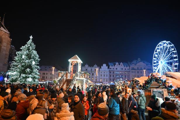 Menschen am Weihnachtsmarkt in Pilsen vor Bürgerhaus Fassaden, Weihnachtsbaum und Riesenrad
