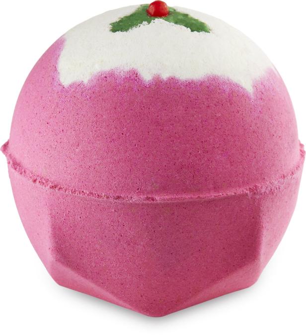 Ein rosafarbener Badezusatz in Form eines Weihnachtspuddings mit weißem Guss und roter Kirsche.