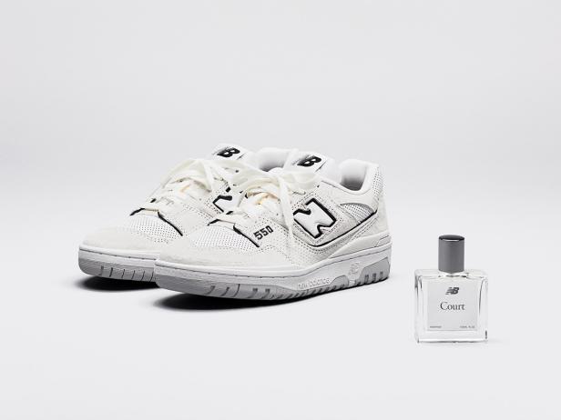 Ein Paar New Balance 550 Sneaker neben einem „Court“-Parfum.