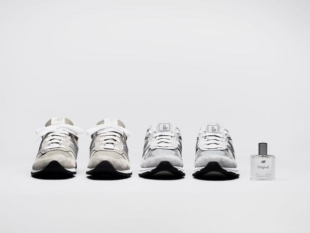 Vier graue New Balance-Sneaker und eine Flasche „NB Original“-Parfüm stehen auf einem weißen Hintergrund.