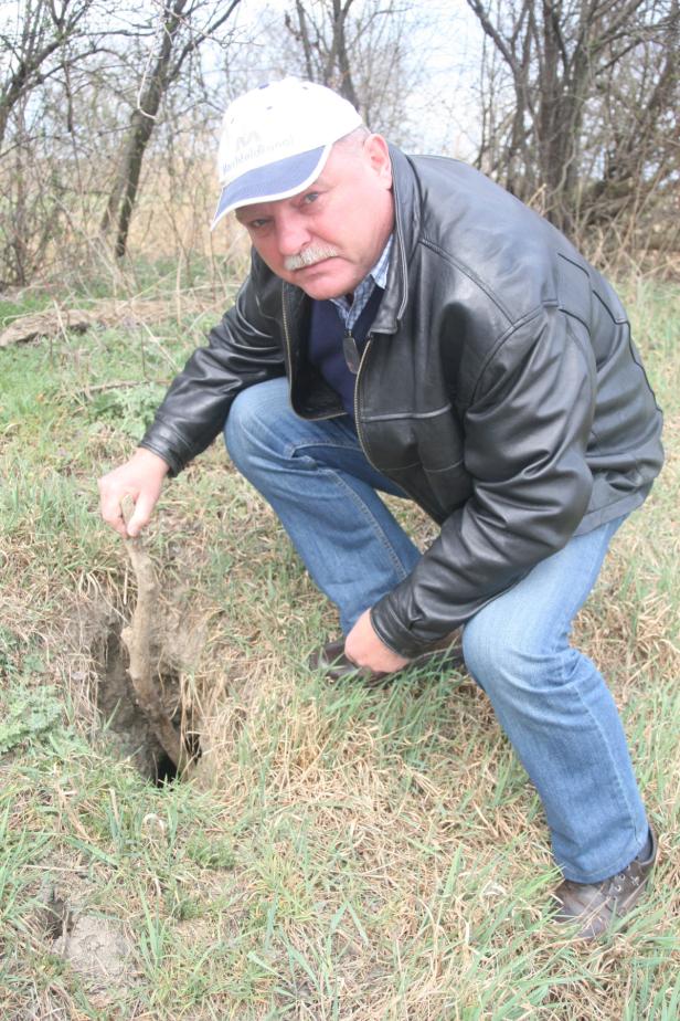 Ein Mann in Lederjacke untersucht ein Loch im Boden.