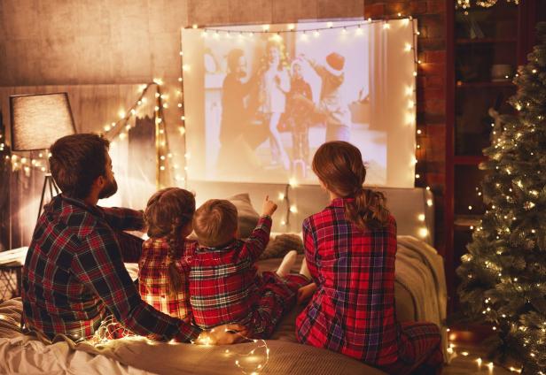 Familie in karierten Pyjamas sieht Weihnachtsfilm an