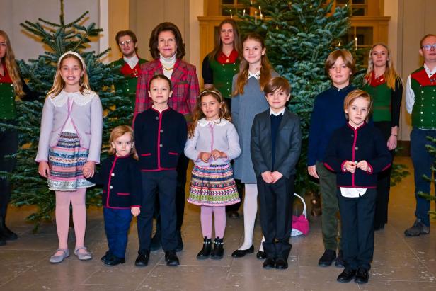 Die schwedische Königsfamilie posiert vor Weihnachtsbäumen.