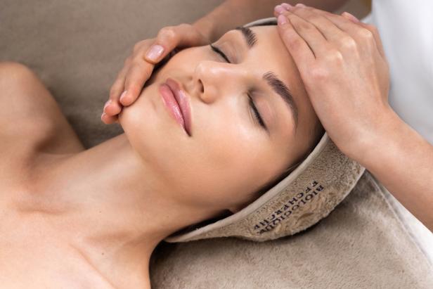 Eine Frau entspannt sich, während sie eine Gesichtsmassage erhält.