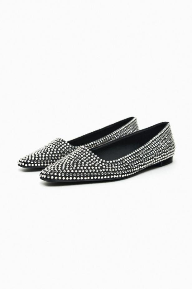 Zwei schwarze, spitze Ballerinas, die mit Strasssteinen besetzt sind.