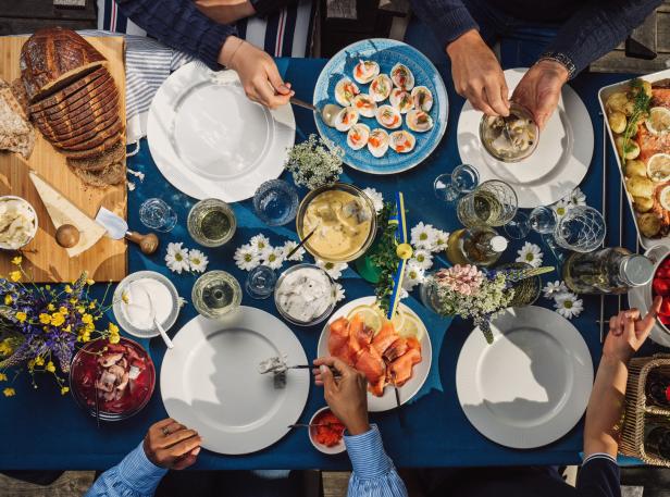Schwedisches Festessen, gedeckter Tisch mit Blumen und Essen, Lachs und Eier, Essen zu Midsommar