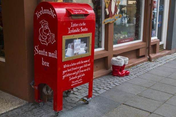 Santa Mail Box in Island auf der Straße in Rekjavik, daneben stehen kleine Weihnachtsmann-Schuhe, Weihnachten in Island
