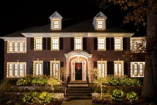 Ein großes Backsteinhaus ist weihnachtlich mit Lichtern geschmückt, ähnlich dem Haus aus „Kevin – Allein zu Haus“.