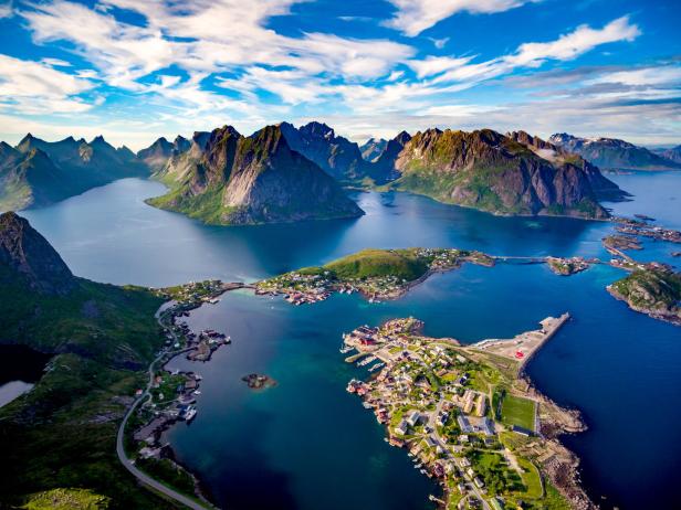Luftaufnahme der Lofoten in Norwegen mit Bergen, Wasser und kleinen Inseln mit Häusern.