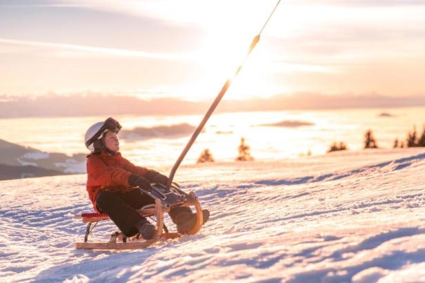 Bergauf-Rodeln in der Wintersonne 