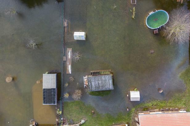 Windehausen in Thüringen am 26. Dezember: Gewächshäuser und ein Pool stehen in einem überschwemmten Garten im Hochwasser.