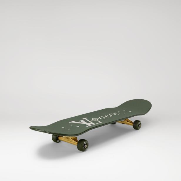 Ein grünes Skateboard mit goldenen Achsen und dem Schriftzug „LV Lovers“.