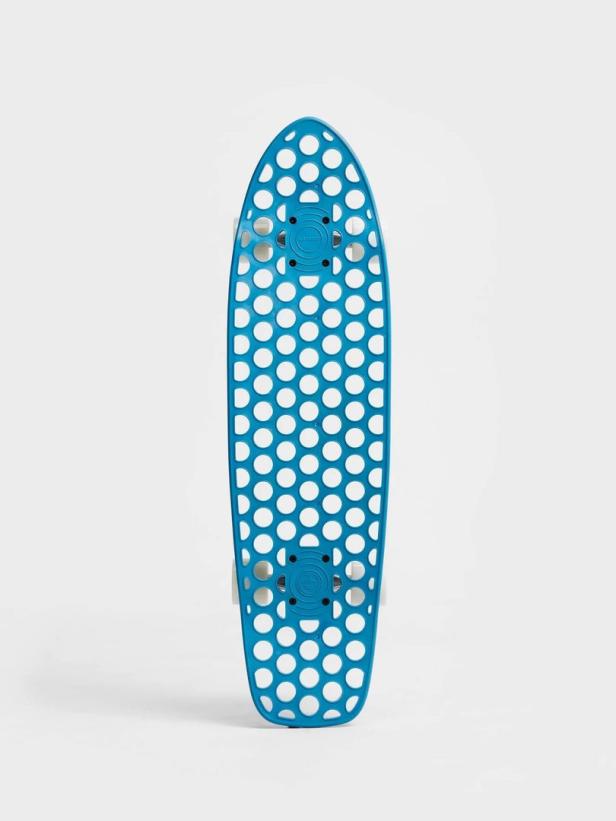 Ein blaues Skateboard mit einem Muster aus weißen Kreisen vor einem weißen Hintergrund.