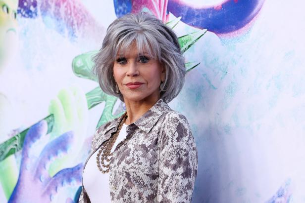 Jane Fonda posiert vor einer bunten Wand.