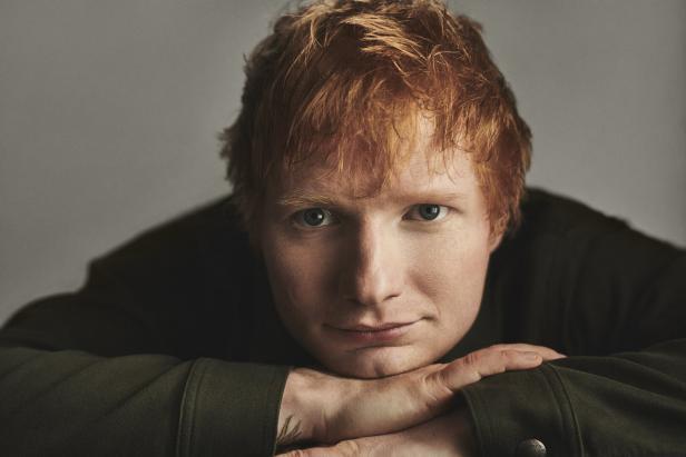 Ein Porträt des Sängers Ed Sheeran, der seine Hände unter sein Kinn gelegt hat.