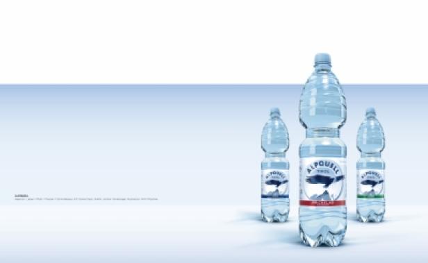 Drei Plastikflaschen Alpquell Tirol Mineralwasser stehen auf einem Tisch.