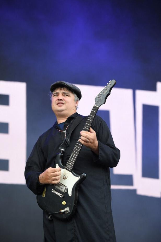 Pete Doherty spielt Gitarre auf einer Bühne.