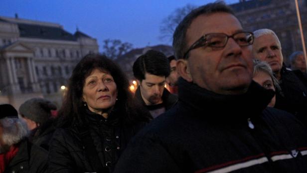 Eine Gruppe von Menschen steht bei Dämmerung im Freien.