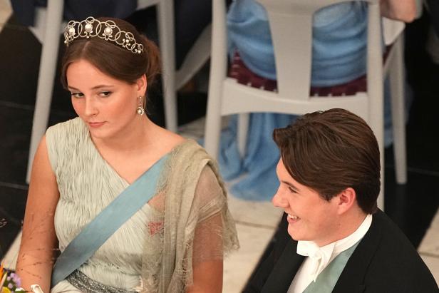 Prinzessin Ingrid Alexandra mit Tiara und ein junger Mann im Anzug sitzen an einem Tisch.