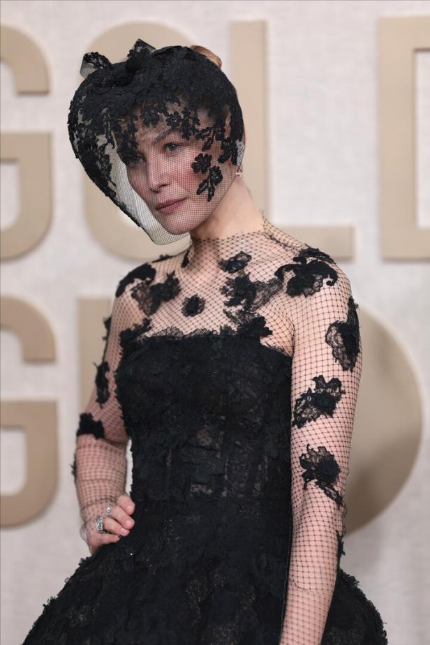 Eine Frau mit einem schwarzen Kleid und einem Schleier mit Blumenmuster.