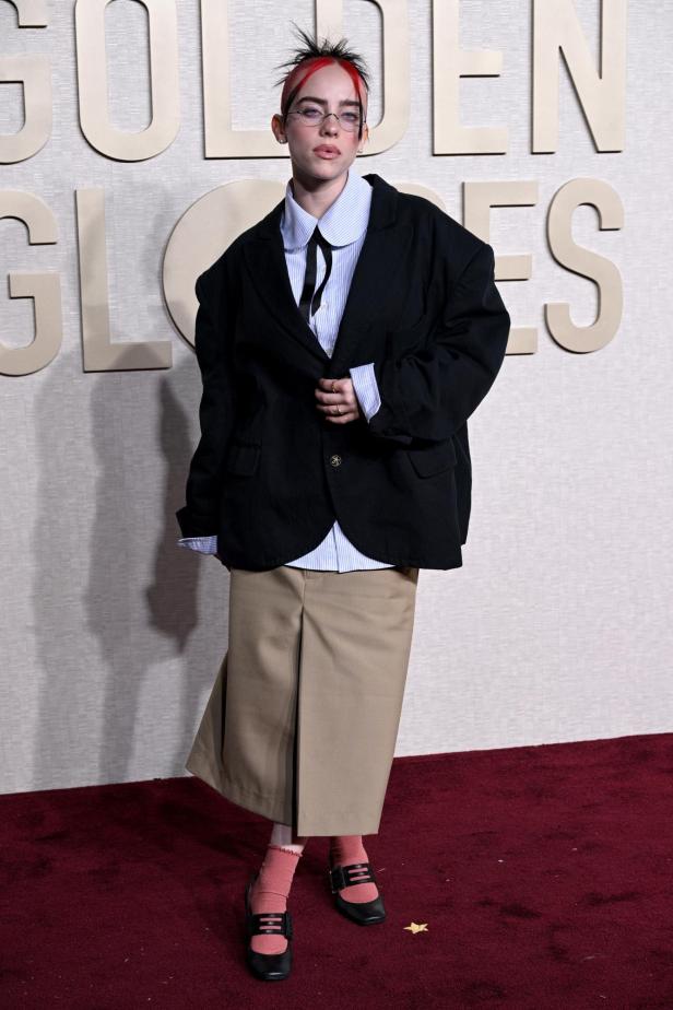Billie Eilish posiert vor dem Hintergrund der Golden Globes.
