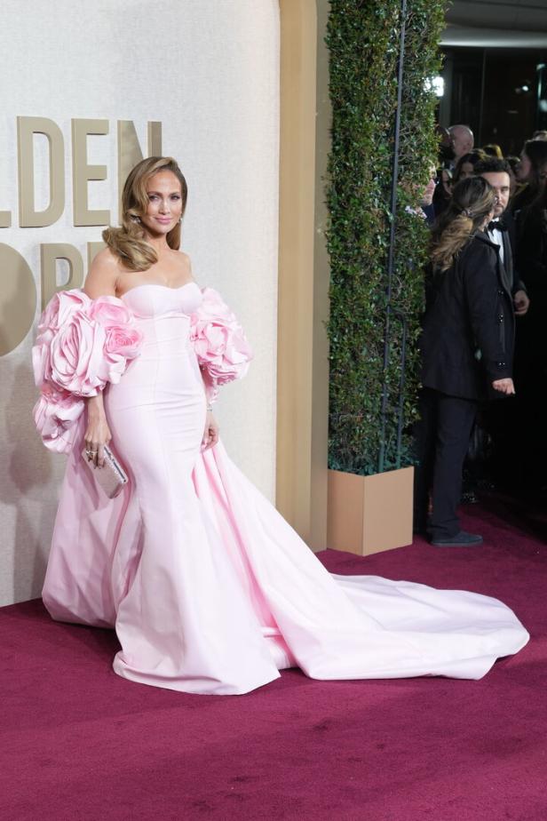 Jennifer Lopez in einem rosa Kleid mit Blumenapplikationen auf dem roten Teppich.