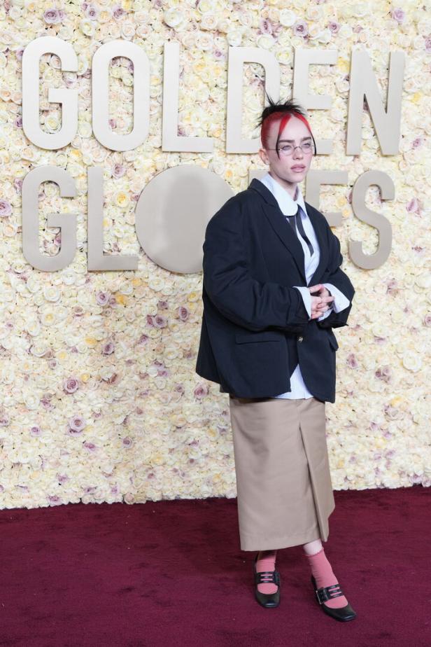 Billie Eilish posiert vor einer Blumenwand bei den Golden Globes.