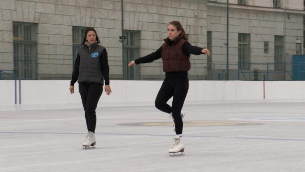 Zwei Frauen laufen auf einer Eisbahn Schlittschuh.
