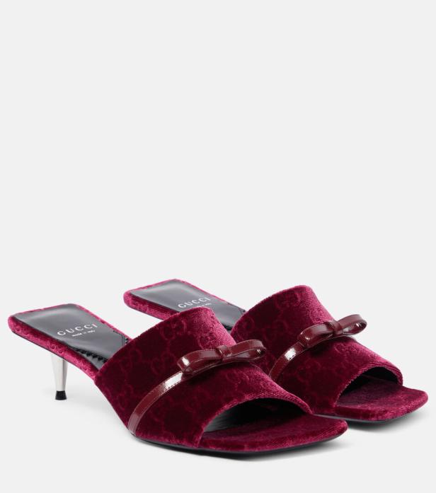 Ein Paar rote Gucci Samt-Sandalen mit Schleifenverzierungen.