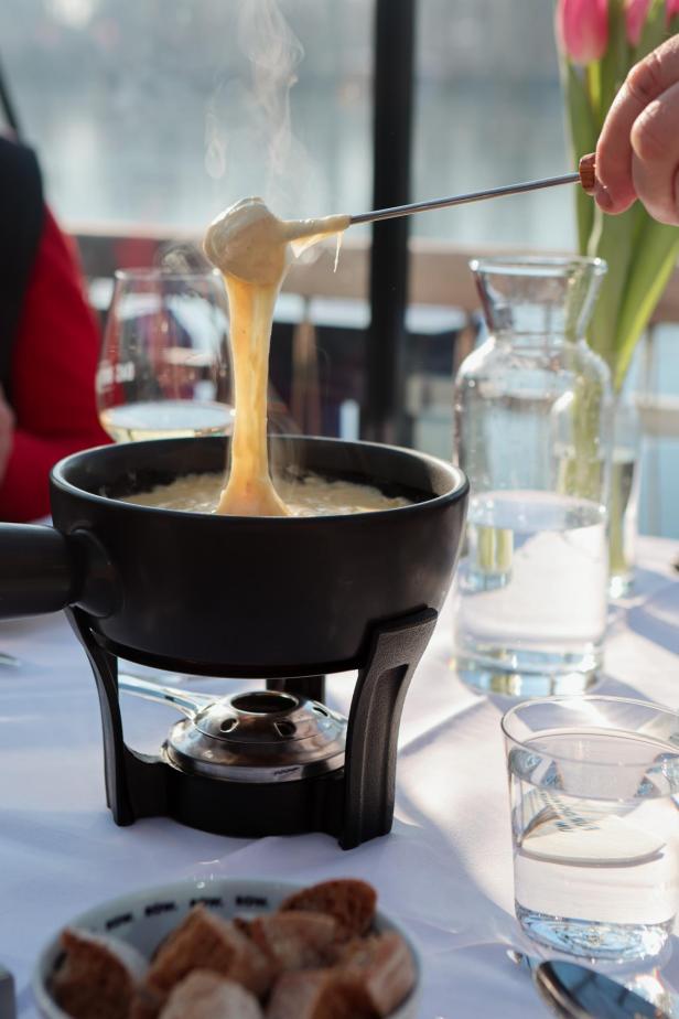 Ein Käsefondue wird mit Brot auf einem Tisch serviert.
