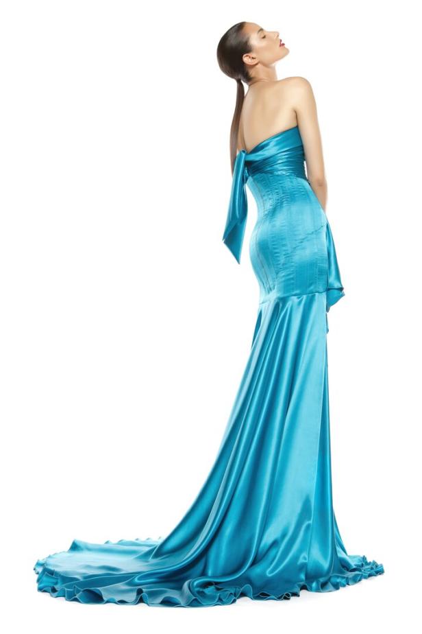 Eine Frau in einem trägerlosen, türkisfarbenen Abendkleid mit Schleppe.