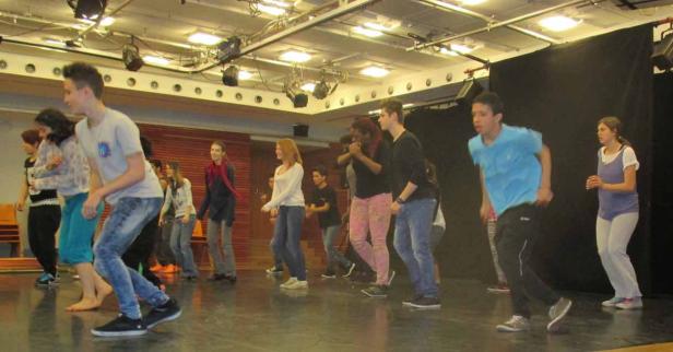 Eine Gruppe von Jugendlichen tanzt auf einer Bühne.