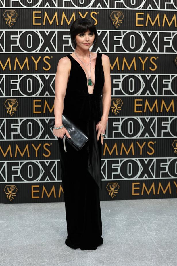 Christina Ricci in einem schwarzen Kleid auf dem roten Teppich der Emmys.