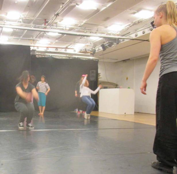 Eine Gruppe von Frauen und Mädchen tanzt in einem Studio.