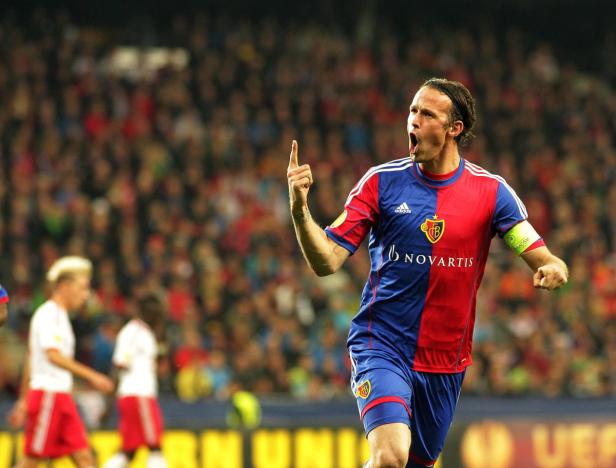 Ein Fußballspieler des FC Basel jubelt mit erhobenem Zeigefinger vor einer Zuschauermenge.