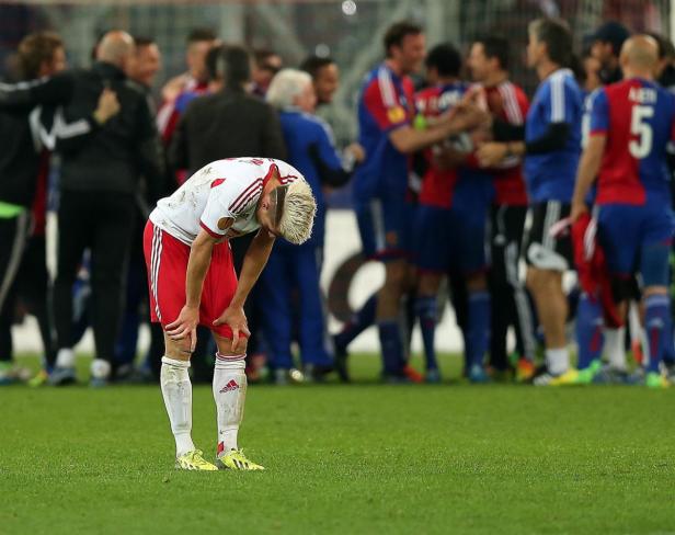Ein enttäuschter Fußballspieler beugt sich mit gesenktem Kopf nach vorne.